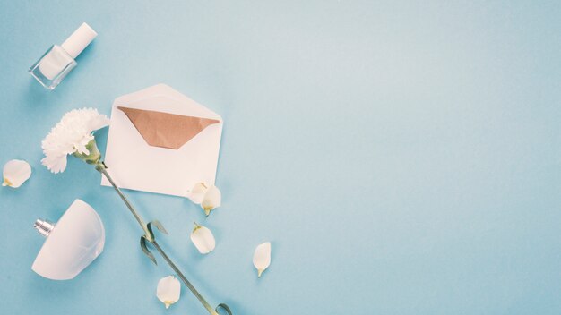 Envelope with white flower and perfume on table