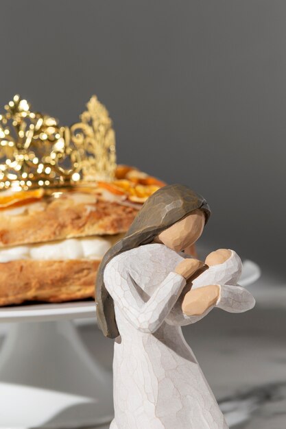 Epiphany day female figurine with dessert and newborn