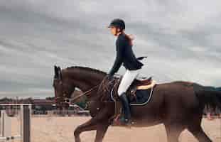 Free photo equestrian sport young girl rides on horse on championship