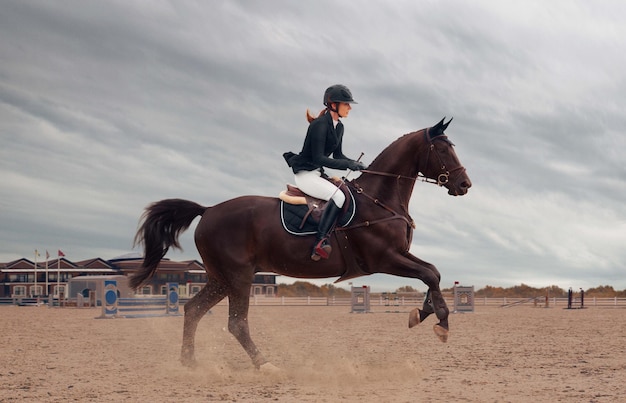 乗馬スポーツ少女はチャンピオンシップで馬に乗る