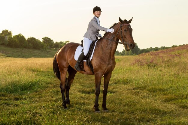 乗馬スポーツ。馬場馬術の高度なテストで馬に乗る若い女性