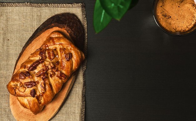 Espresso coffee braided with pecans and maple syrup on a dark table Sweet pastries for breakfast at the hotel View from above