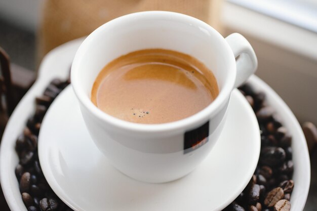 Espresso in cup on coffee beans