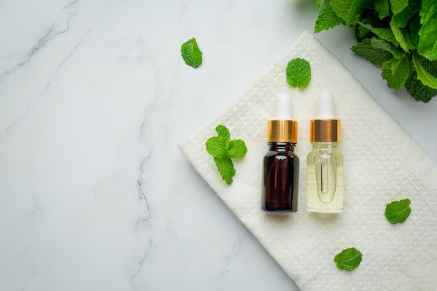 Free photo essential oil of peppermint in bottle with fresh green peppermint