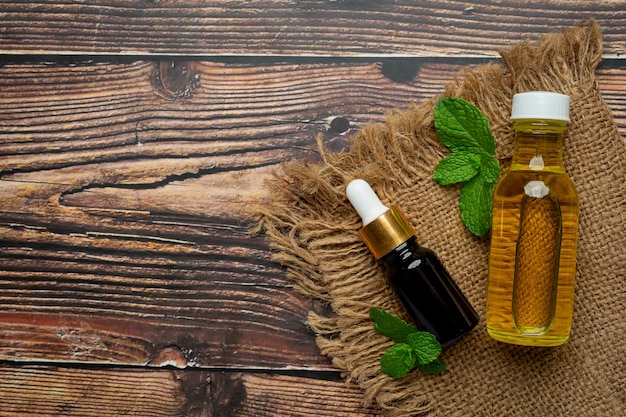 Foto gratuita olio essenziale di menta piperita in bottiglia con menta piperita verde fresca