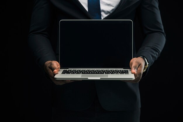 Ethnic businessman showing laptop