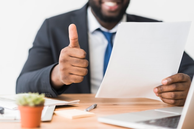 Ethnic employee gesturing thumb up