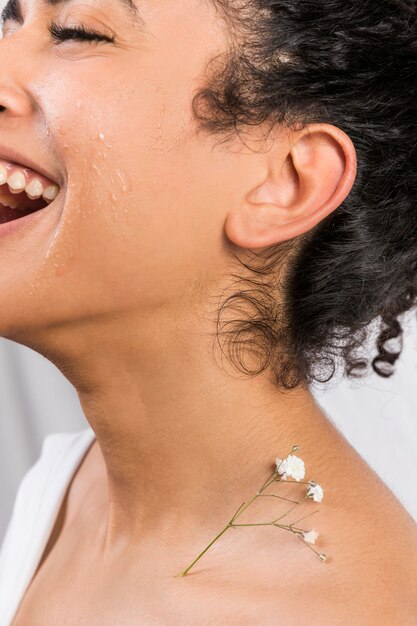 Ethnic happy woman with plant on neck