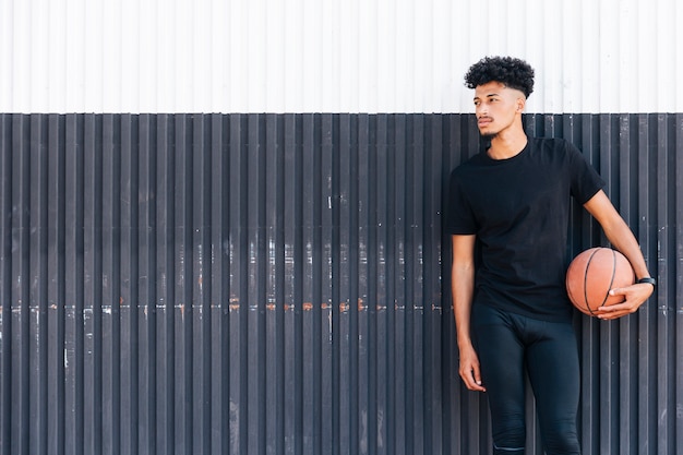 Free photo ethnic man with basketball looking away