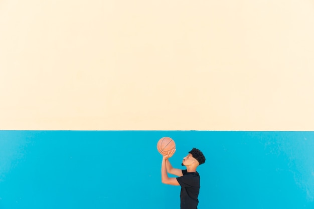 Ethnic sportsman preparing to throw basketball