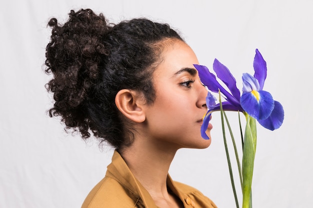 Foto gratuita donna etnica con fiore di iris blu