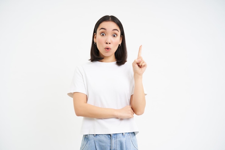 無料Photo ユーレカ アジアの女性は指を 1 本上げますが、白い b に対して上向きにアイデアを持った提案があります