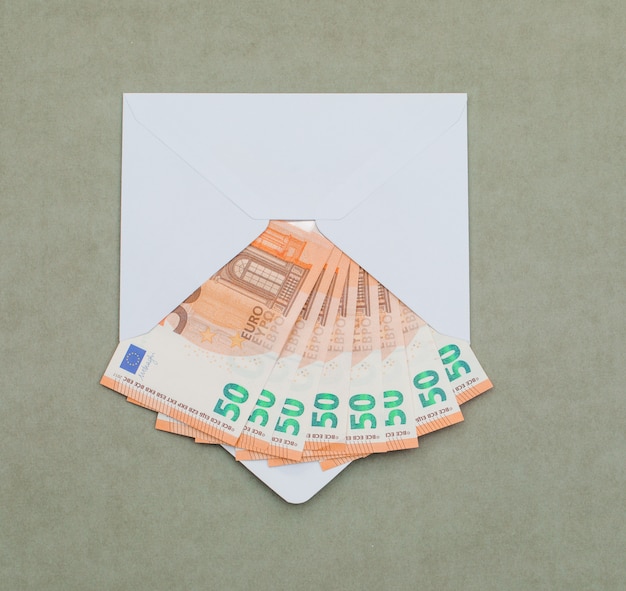 녹색 회색 테이블에 봉투에 유로 지폐.