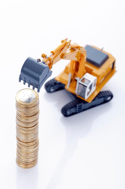 Euro money coins with excavator on white