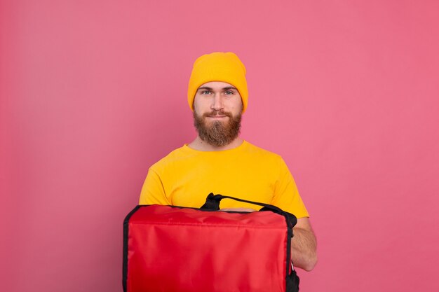 European bearded delivery man with box with food on pink