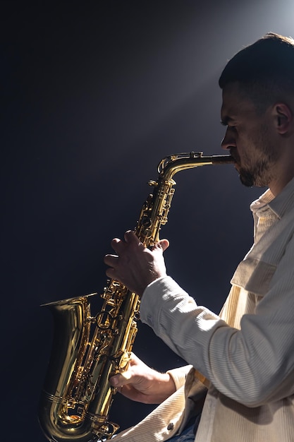 Free photo a european man plays the saxophone in the dark