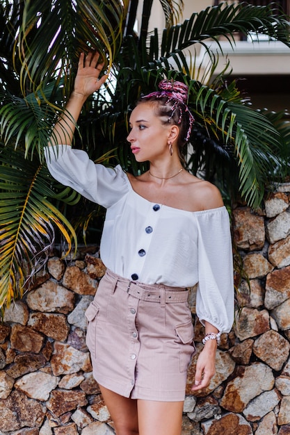 Free photo european stylish woman with pink colorful summer braids in beige skirt and white blouse