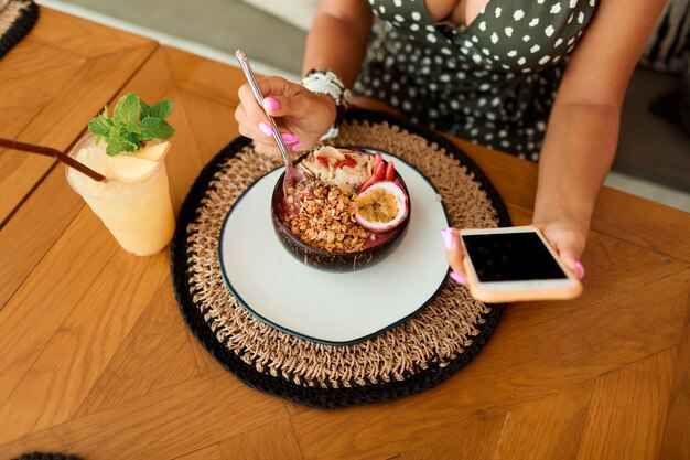 Donna europea che utilizza telefono cellulare nel caffè.