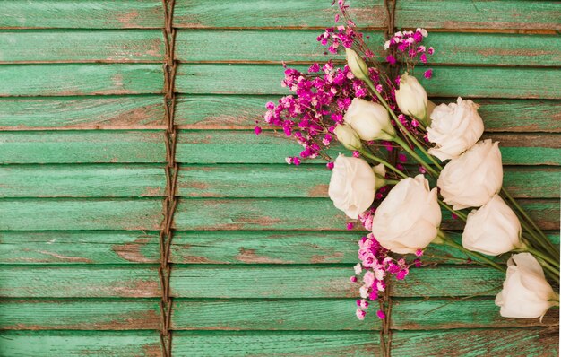 Eustoma and baby's-breath flowers against green wooden shutter background