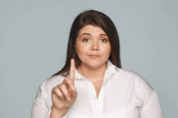 Free photo don't even try. beautiful self-confident overweight young woman with curvy body and dark hair shaking index finger, making no or rejection gesture, not interested in your opinion. selective focus