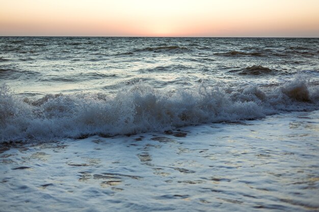 夕方の暗い海の青い波日没砂浜柔らかい波の海の泡自然背景壁紙 プレミアム写真