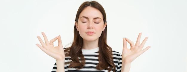 Foto gratuita tutto sotto controllo giovane donna che medita in piedi in posa zen yoga mantiene la calma posando con