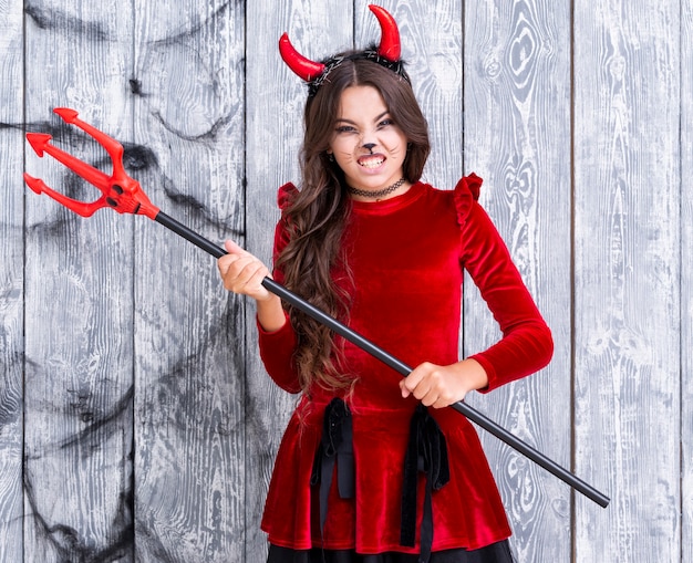 Ragazza diabolica che tiene il tridente di halloween