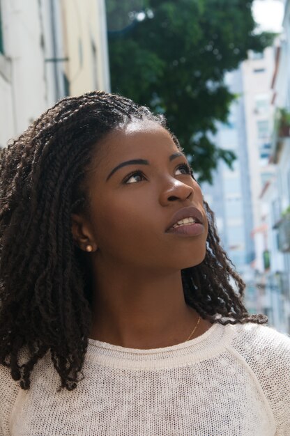 Excited African American female tourist walking in old city