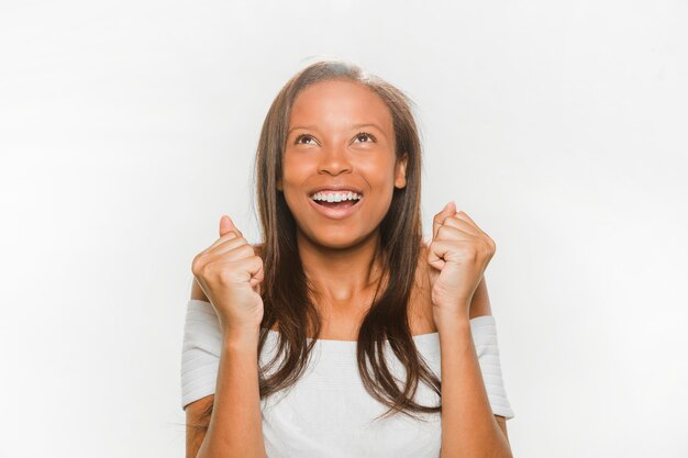 Excited african teenage girl over white background