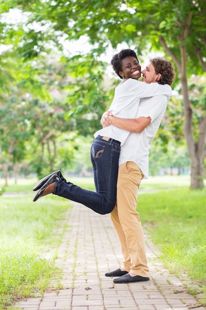 Free photo excited african woman jumping to hug boyfriend