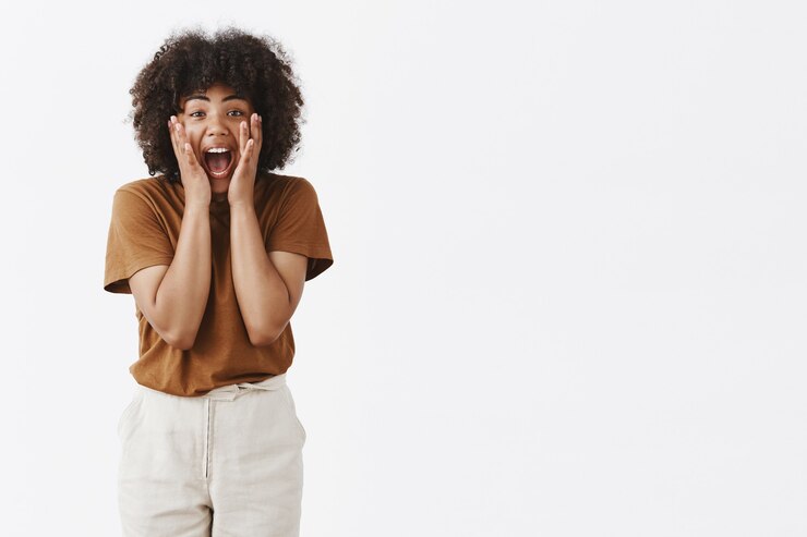 Free Photo excited amazed african american young woman screaming and holding hands on face being thrilled and enthusiastic