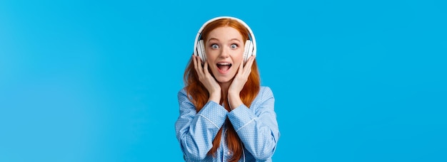 Free photo excited and amused attractive caucasian redhead woman in pyjama screaming from fascination and amaze