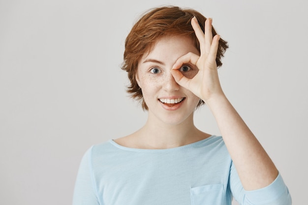 Free photo excited and amused redhead girl posing against the white wall