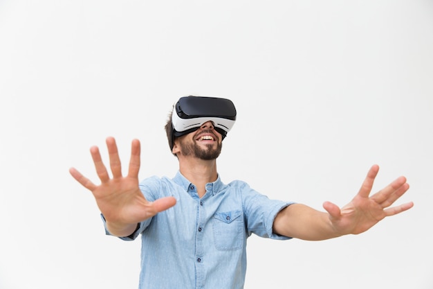 Excited bearded guy in VR goggles enjoying experience