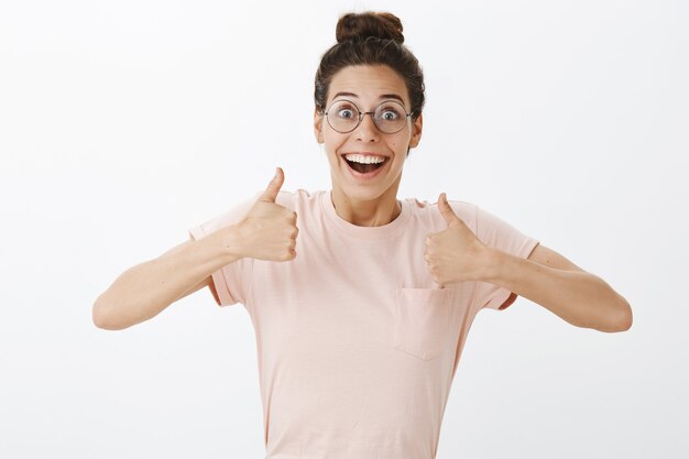 Free photo excited beautiful girl with glasses posing against the white wall