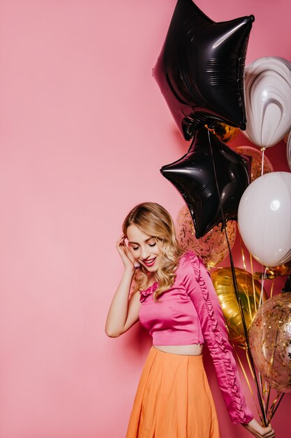 Excited blonde woman preparing for party