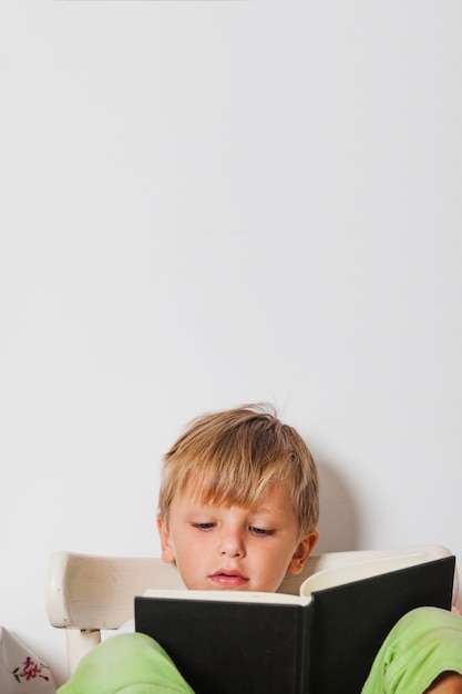 Eccitato ragazzo leggendo il libro