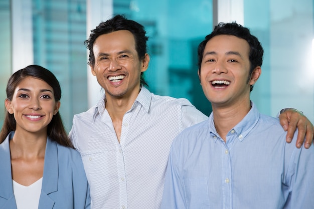 Excited business team looking at camera in office