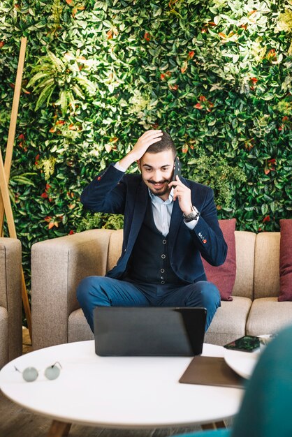 Foto gratuita eccitato uomo d'affari parlando al telefono