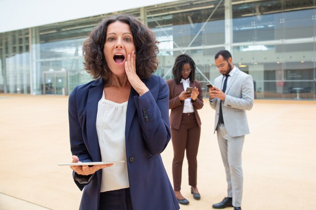 Excited businesswoman with tablet getting great shocking news