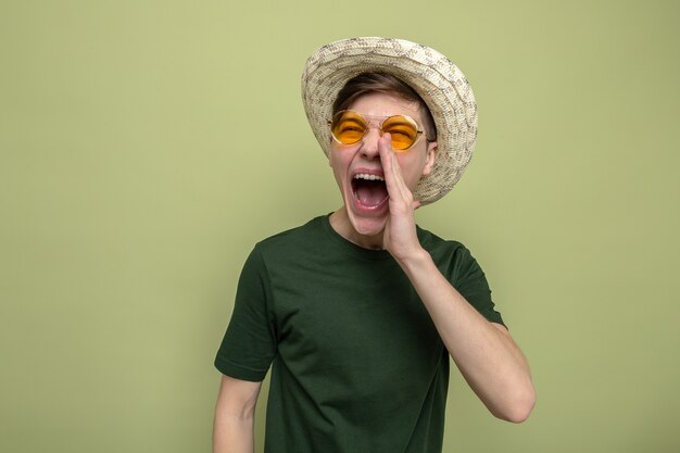 Excited calling someone young handsome guy wearing hat with glasses 