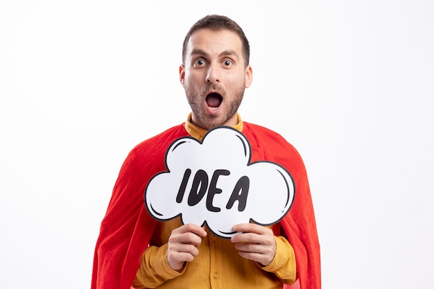 Free photo excited caucasian superhero man with red cloak holds idea bubble