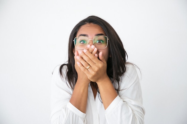 Возбужденная жизнерадостная женщина в очках шокирована новостями