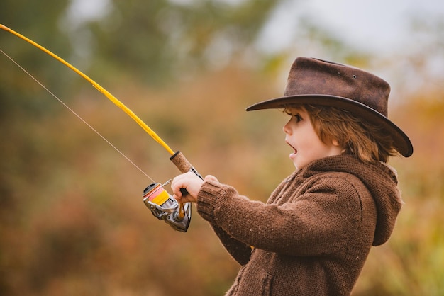 Excited child boy fishing with spinning reel. american children and happy childhood concept.