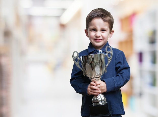 Free photo excited child holding a trophy