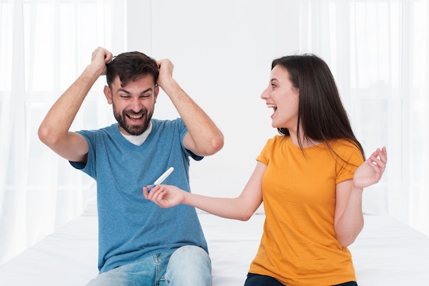 Excited couple holding pregnancy test