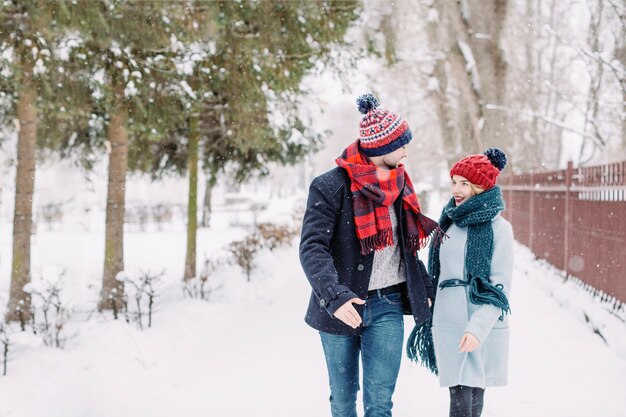 Excited couple in love running in snowfall