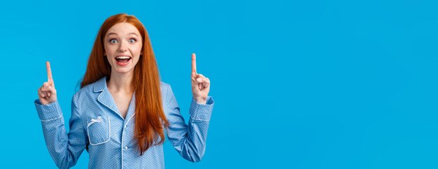 Free photo excited cute redhead girl in nightwear smiling amused and fascinated telling about incredible choice