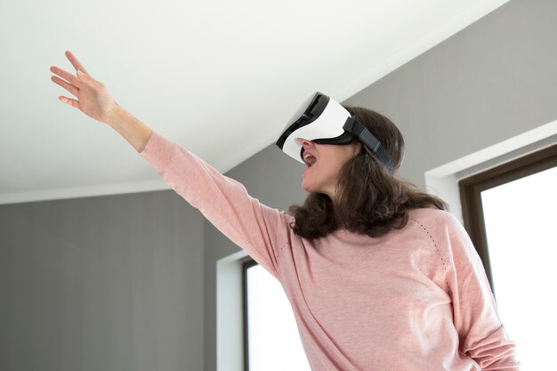 Excited emotional woman pointing up while playing video game