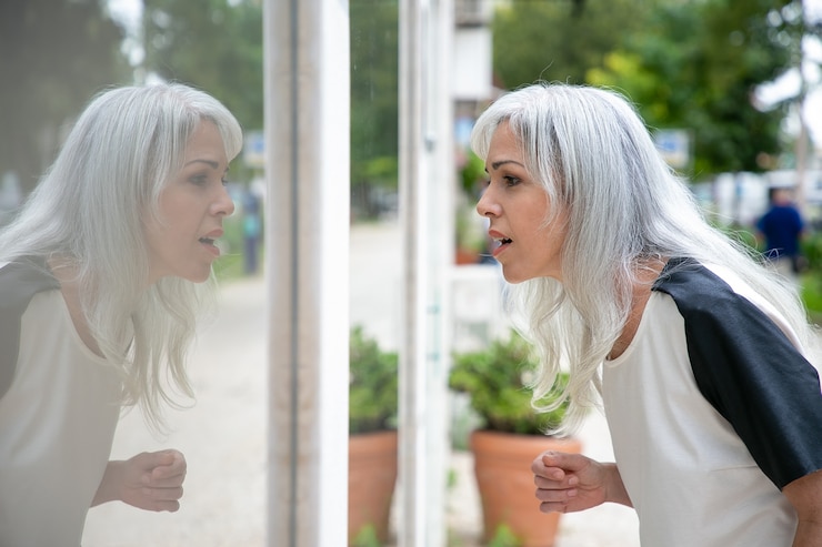 Free Photo excited female shopaholic staring at shop window with open mouth, standing at store outside. side view. window shopping concept